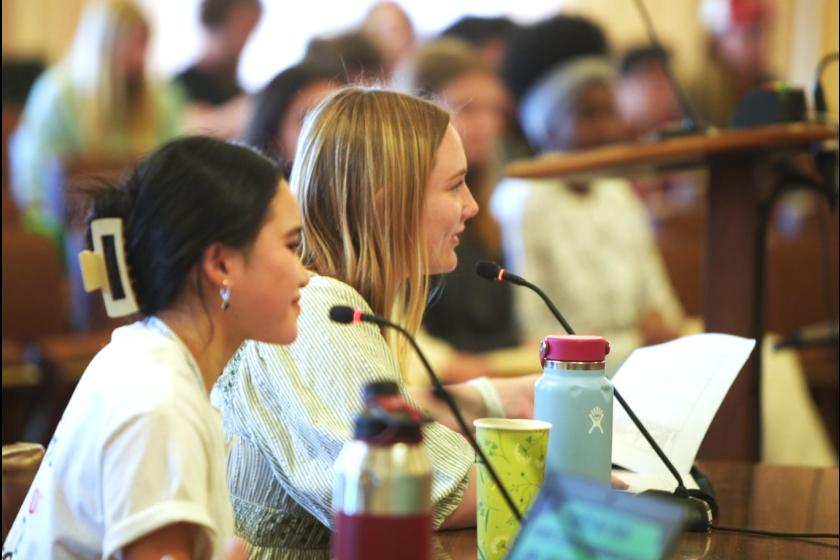 Two female students speak into microphones at last year's Youth Town Hall.